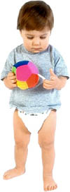 Little toddler girl in diapers holding a soft ball.