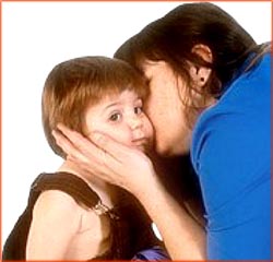 Toddler kissed by mother. 