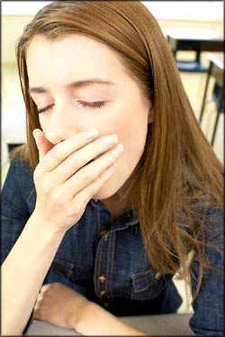 Teens need to sleep more. Teen girl student yawning.